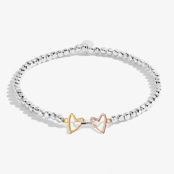 Joma jewellery stretch beaded bracelet with three heart charms in silver, gold and rose gold.