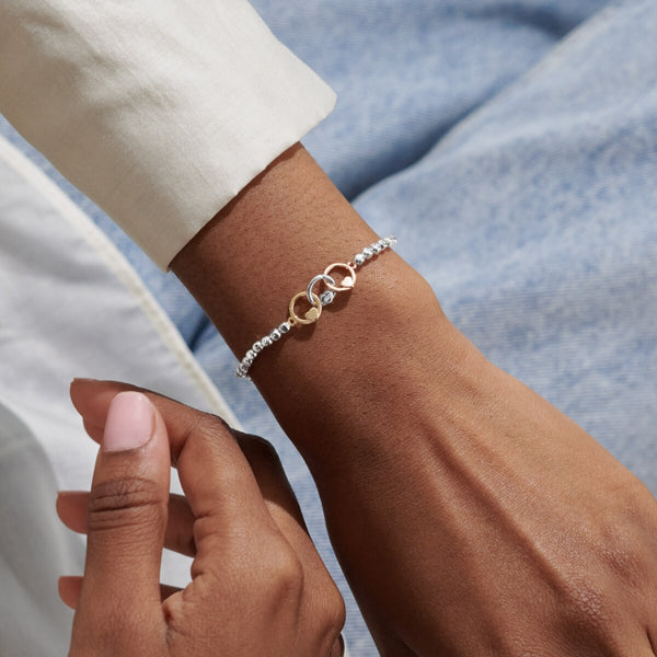 Joma jewellery beaded stretch bracelet with adjoined circle charms in silver, gold and rose gold with heart detailing.