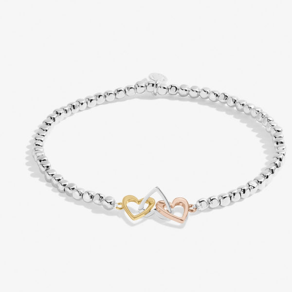 Joma jewellery beaded bracelet with adjoining heart charms in silver, gold and rose gold presented on foil stamped sentiment card.