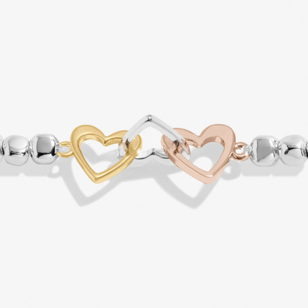 Joma jewellery beaded bracelet with adjoining heart charms in silver, gold and rose gold presented on foil stamped sentiment card.