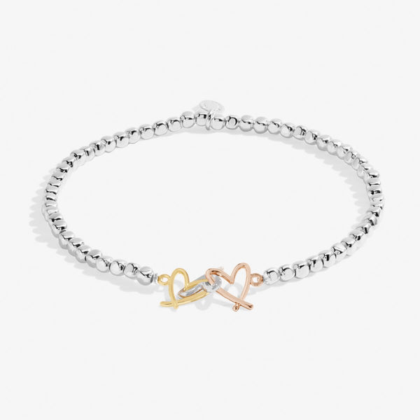 Joma Jewellery beaded bracelet with three open heart charms in silver, gold and rose gold.