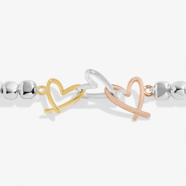 Joma Jewellery beaded bracelet with three open heart charms in silver, gold and rose gold.