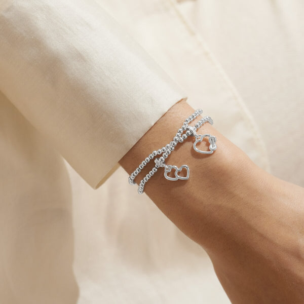 Joma Jewellery Infinity interlinked bracelets with hanging open heart charms and infinity symbol detail.