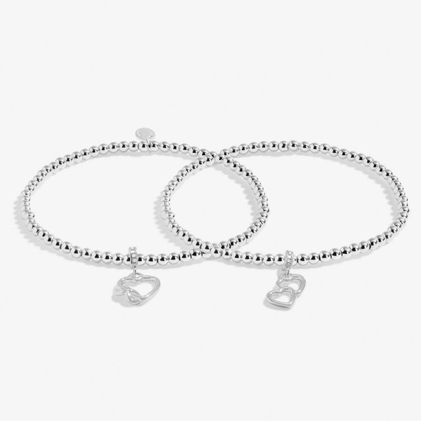 Joma Jewellery Infinity interlinked bracelets with hanging open heart charms and infinity symbol detail.