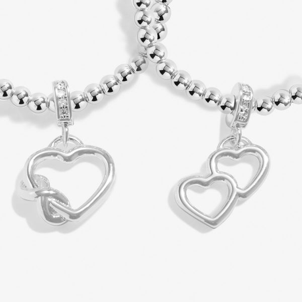 Joma Jewellery Infinity interlinked bracelets with hanging open heart charms and infinity symbol detail.