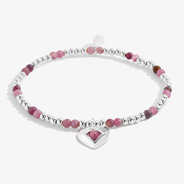 Joma Jewellery October birthstone stretch bracelet with pink semi-precious gemstones and silver hanging heart charm.