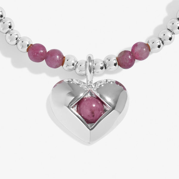 Joma Jewellery October birthstone stretch bracelet with pink semi-precious gemstones and silver hanging heart charm.