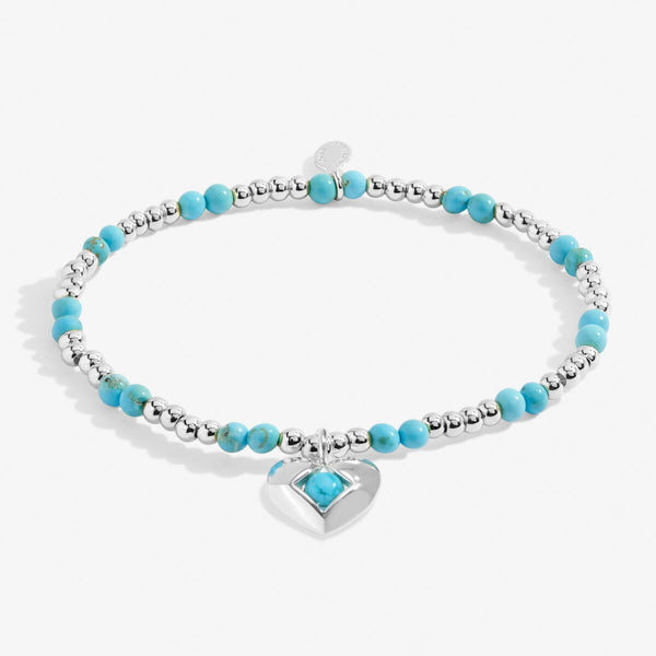 Joma Jewellery December birthstone stretch beaded bracelet featuring semi precious gemstones and a silver plated hanging heart charm.