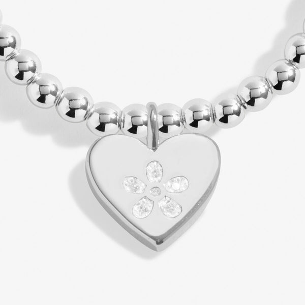 Joma Jewellery silver plated beaded bracelet with hanging heart charm and stamped flower highlight.