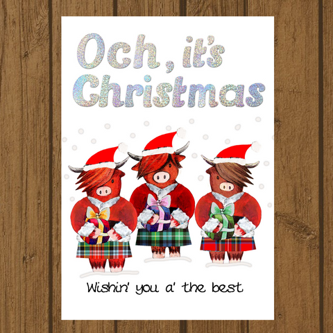 Scottish Christmas card with highland cows wearing Santa hats and holding presents with holographic foil detail.