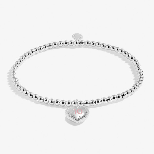 Joma girls 10th birthday bracelet with silver plated beads and a hanging heart charm with 10 stamped in pink.