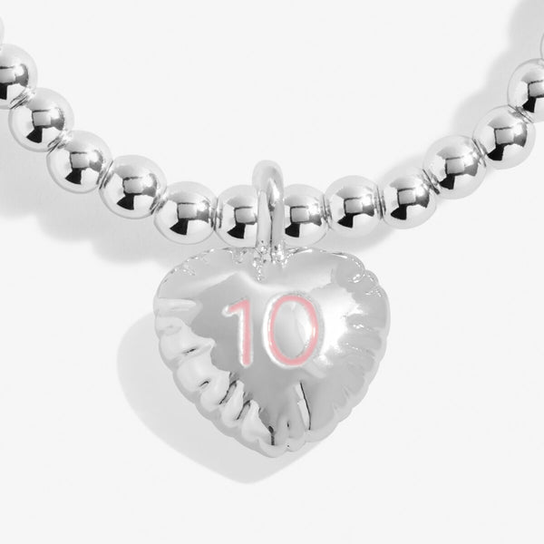 Joma girls 10th birthday bracelet with silver plated beads and a hanging heart charm with 10 stamped in pink.