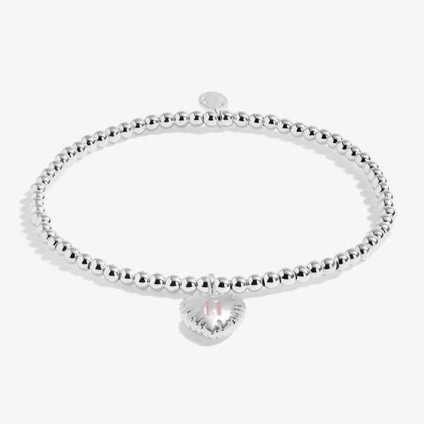 Joma jewellery girls 11th birthday bracelet with silver plated beads and a hanging heart charm with 11 stamped in pink.