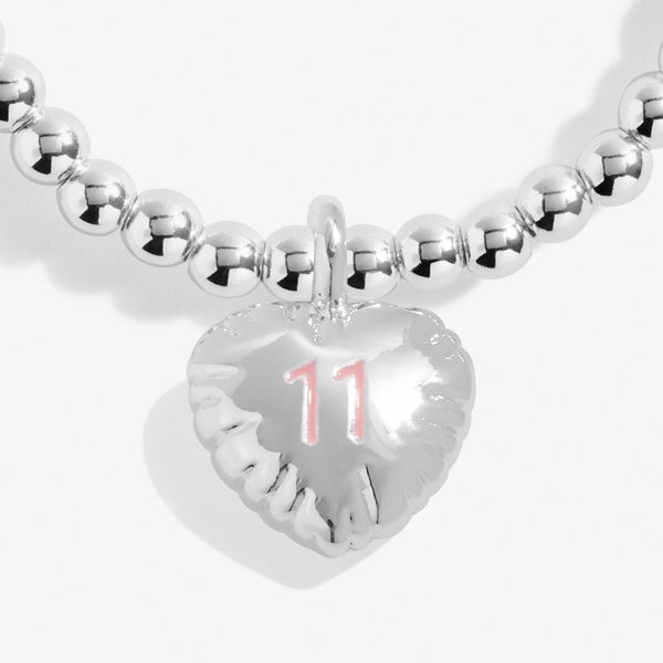 Joma jewellery girls 11th birthday bracelet with silver plated beads and a hanging heart charm with 11 stamped in pink.