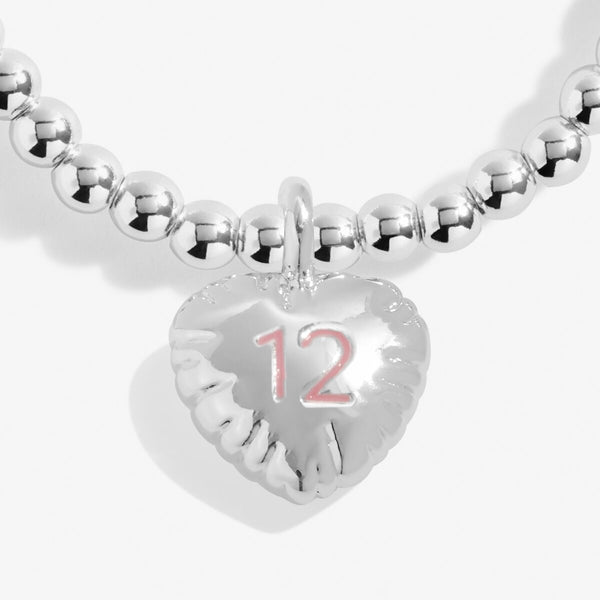 Joma jewellery girls 12th birthday bracelet with silver plated beads and hanging heart charm stamped with a pink '12'.