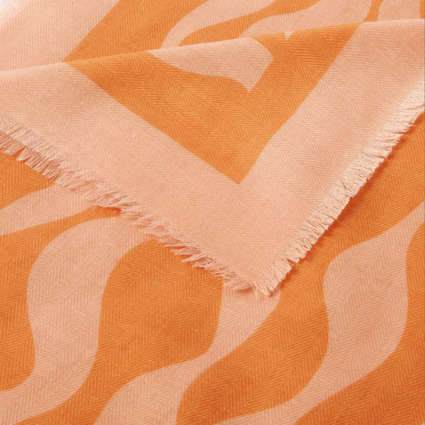 Katie Loxton ripple wave printed scarf in orange and pink with stylish frayed edges and lightweight fabric.