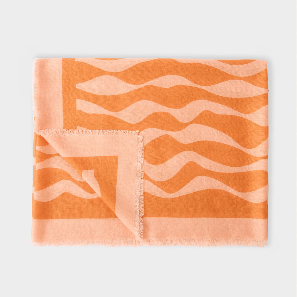 Katie Loxton ripple wave printed scarf in orange and pink with stylish frayed edges and lightweight fabric.