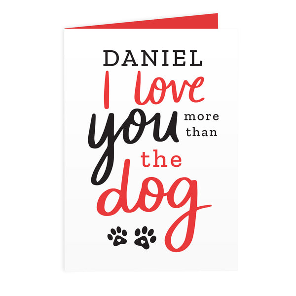 This personalised card features the wording 'I Love You More Than The Dog' and cute pawprint graphics 