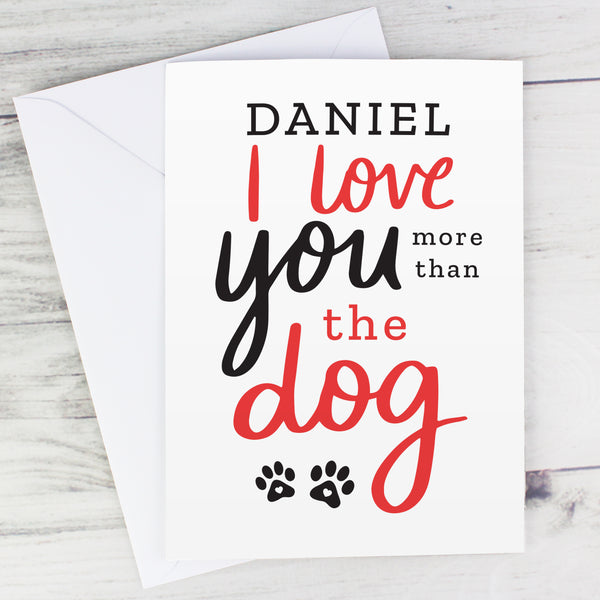 This personalised card features the wording 'I Love You More Than The Dog' and cute pawprint graphics 